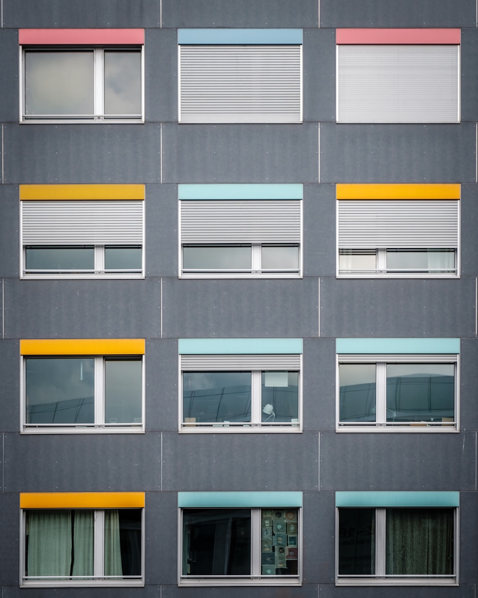 photo of gray concrete building with clear glass windows during daytime